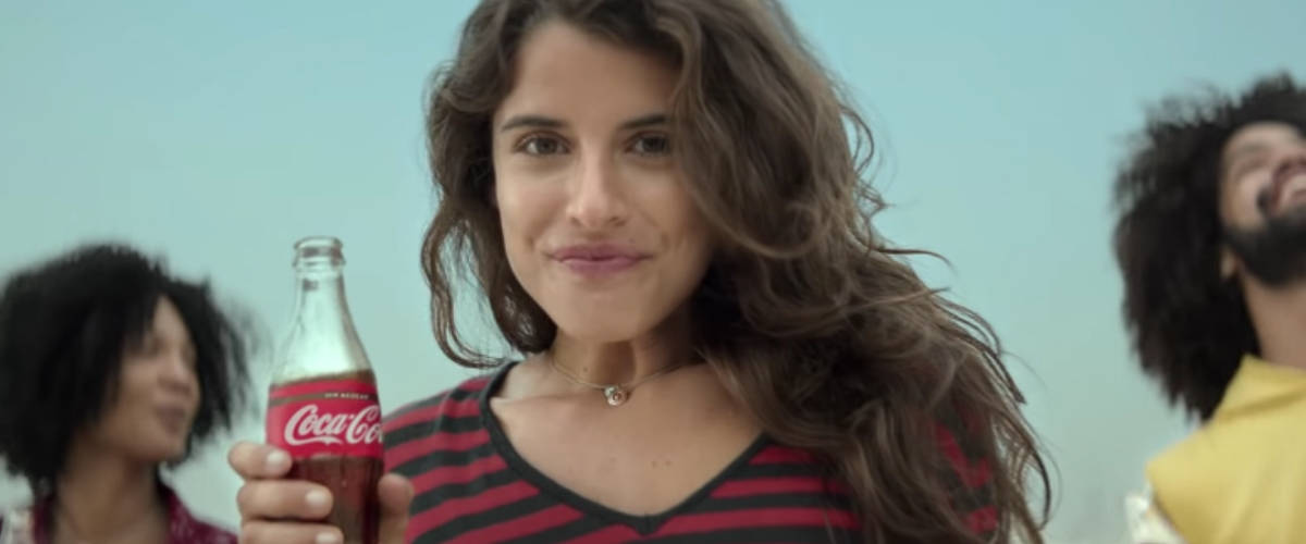 Le Top 10 des pubs les plus vues sur YouTube Une femme avec une bouteille de Coca-Cola dans la main