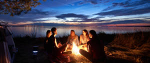 Un groupe de jeunes gens autours d'un feu le soir