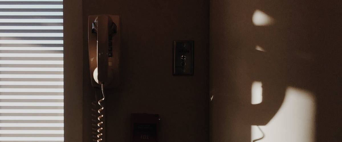COM-ENT : une ligne d’écoute contre le harcèlement en communication Un téléphone mural dans un salon à la lumière du matin