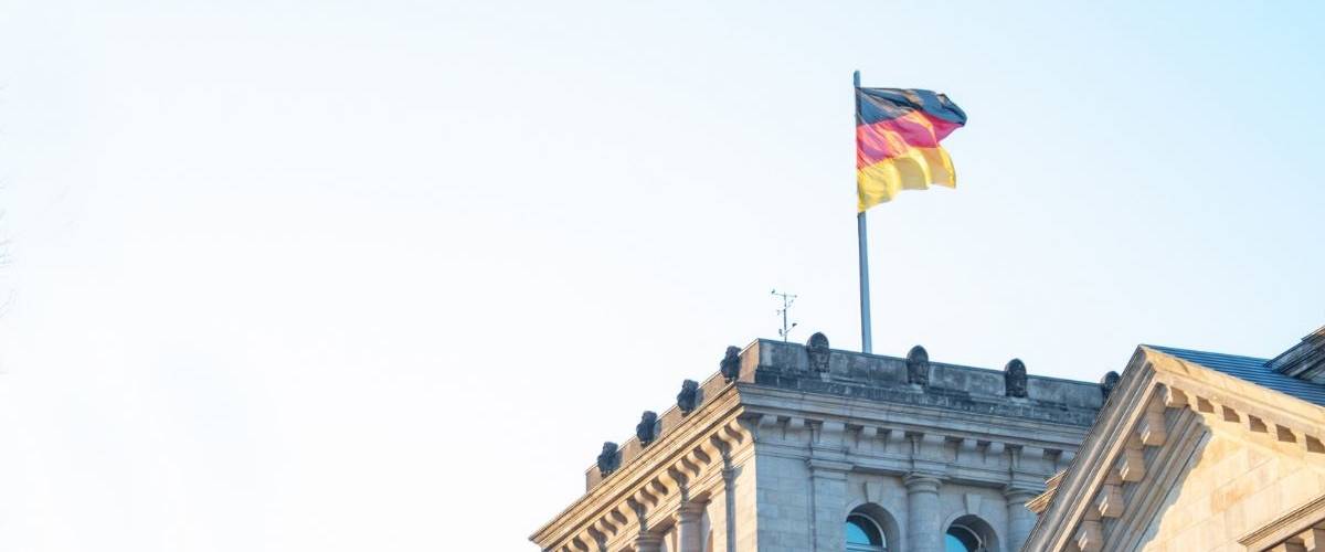 Les Allemands vont pouvoir utiliser leur iPhone comme pièce d’identité Un drapeau allemand au dessus d'un bâtiment