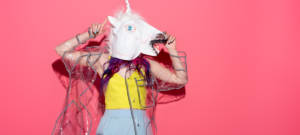 Une femme avec une tete de licorne sur un fond rose