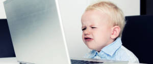 un enfant grincheux devant un ordinateur