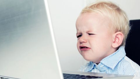 un enfant grincheux devant un ordinateur