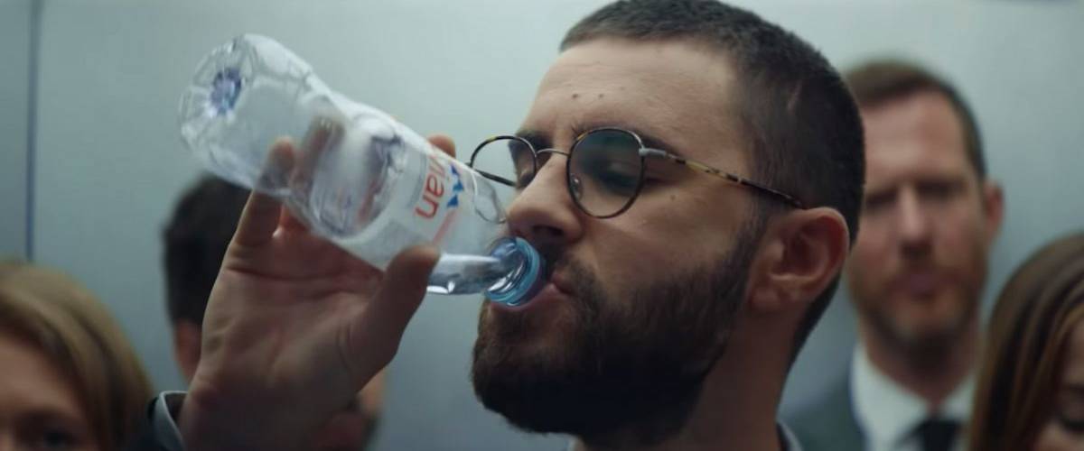 Evian s'entoure de trois figures de Youtube pour sa nouvelle campagne Le youtubeurs Cyprien boit une bouteille d'eau evian dans un ascenseur
