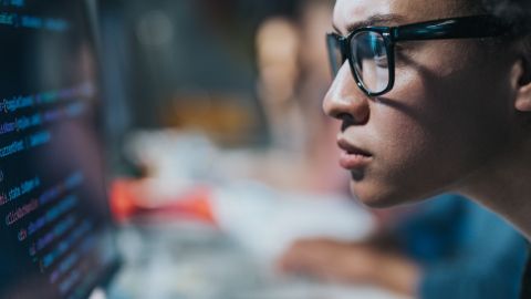 Une femme regarde un écran d'ordinateur inquiète.