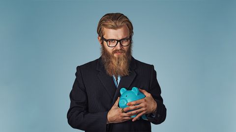 Un homme barbu protège sa tirelire