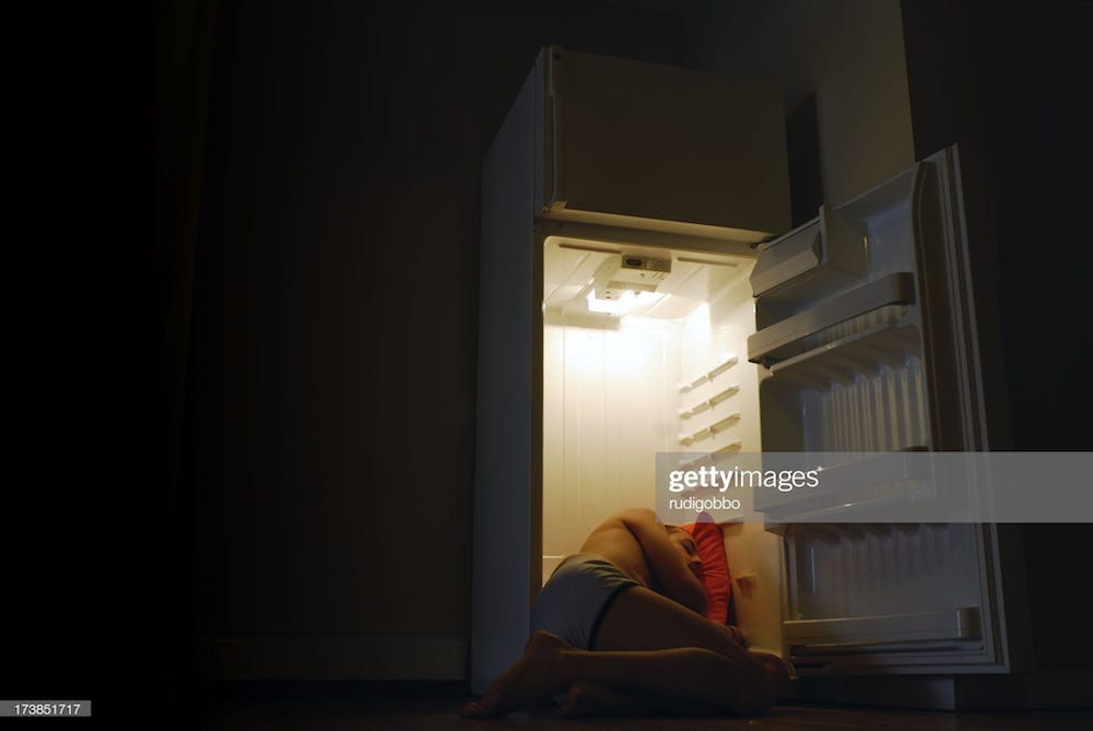 un homme allongé dans le frigo