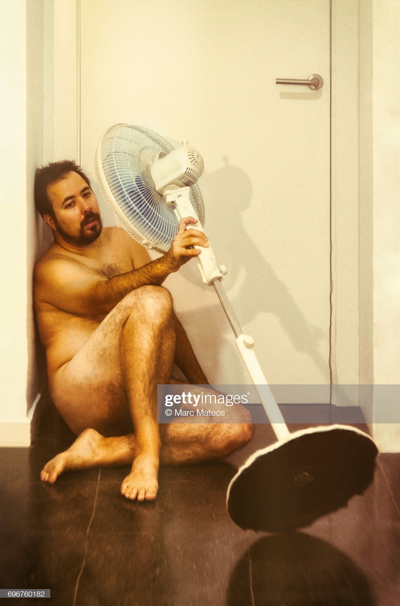 un homme nu avec un ventilateur