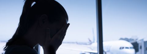 Honte de prendre l'avion ? Ces quatre aéronefs promettent de moins polluer Silhouette d'une femme se cachant les yeux avec les mains, derrière elle un avion sur le tarmac.