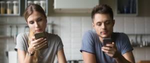 Deux jeunes en couple regardent leurs téléphones