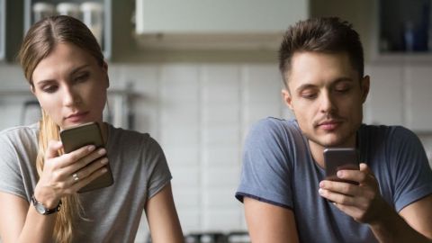 Deux jeunes en couple regardent leurs téléphones