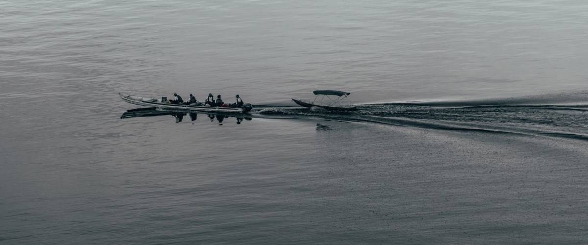 Journaliste sur l'environnement, un métier à risque ? Un long bateau longe un lac exotique
