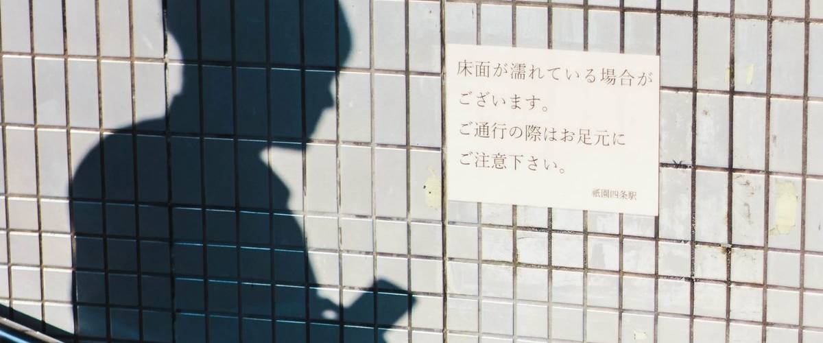 Line instaure le crédit social sur sa plateforme au Japon Ombre d'un homme tenant son téléphone, sur le coté une affiche japonaise