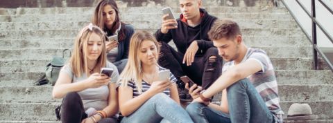 Pour s'informer, on continue d'aller sur Facebook. une bande de jeune assis sur des escalier qui regardent leur portables.