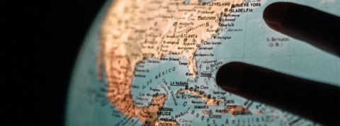 Comment changer le monde ? une mappemonde illuminée avec des mains