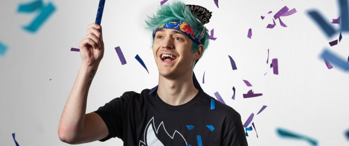 Ninja, le streamer numéro 1 de Twitch, gagne 500 000 dollars par mois une jeune homme aux cheveux bleu dans les confetis.