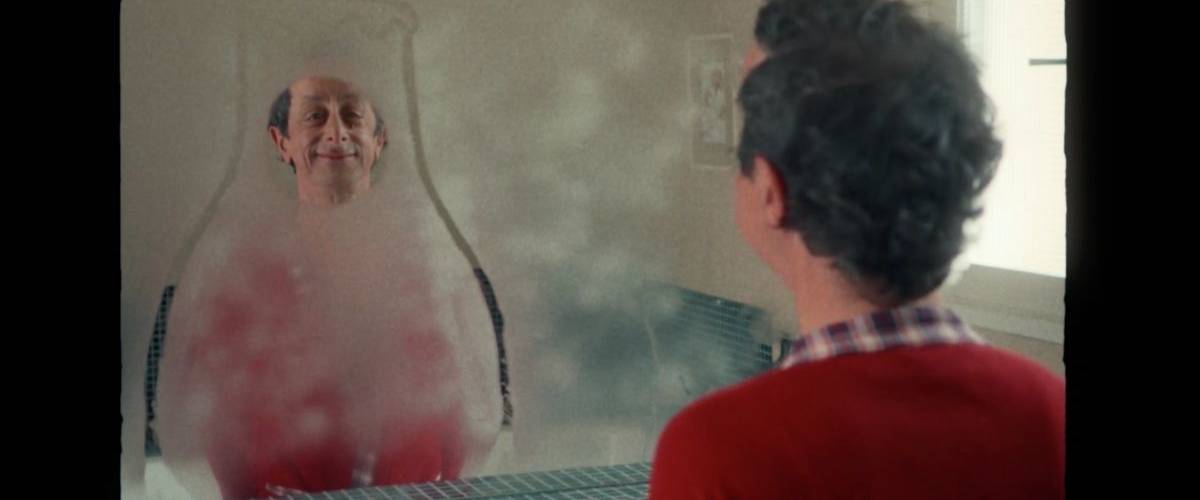 Un homme se tient devant son miroir