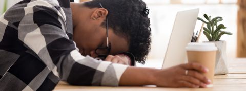 Pourquoi sommes-nous fatigués au travail ? une femme en train de dormir devant son ordinateur