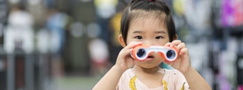 En Chine, le crédit social est très lié au commerce en ligne Une petite fille chinoise qui tient des jumelles dans les mains