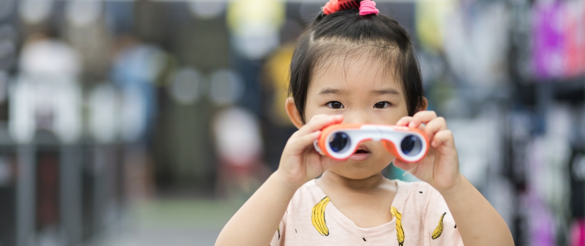 En Chine, le crédit social est très lié au commerce en ligne Une petite fille chinoise qui tient des jumelles dans les mains