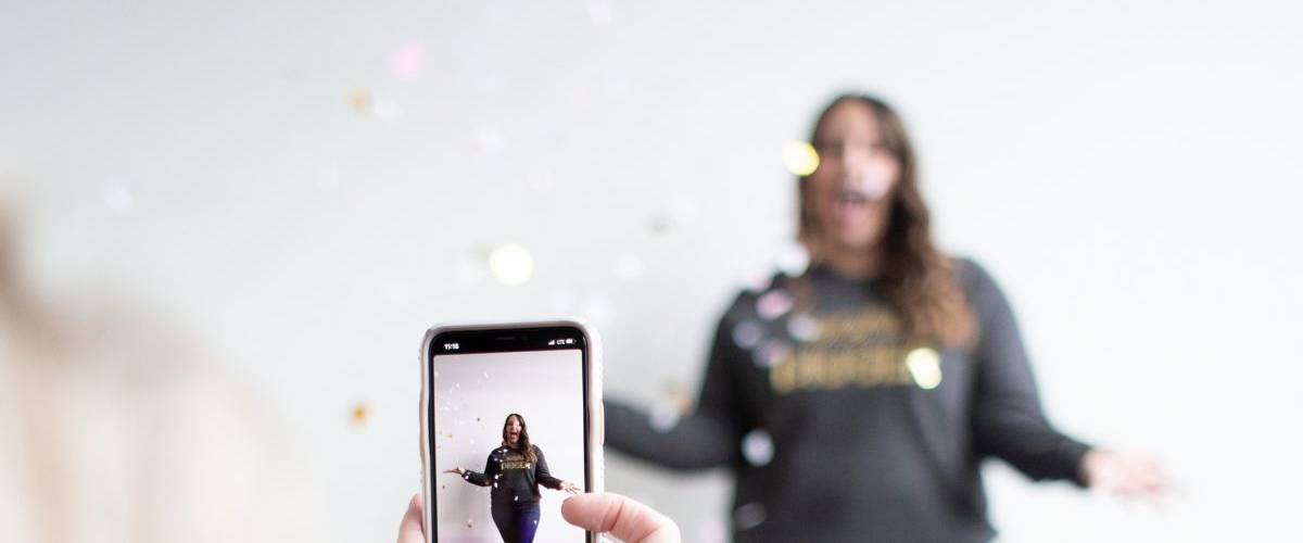 La publicité va (sûrement) débarquer sur TikTok Une jeune femme se fait filmer par son ami, devant un mut blanc