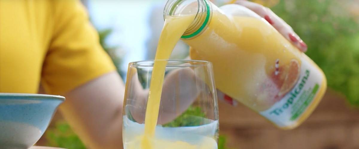 PepsiCo transforme les briques Tropicana en bouteilles plastiques Gros plans sur une main versant du jus d'orange Tropicana
