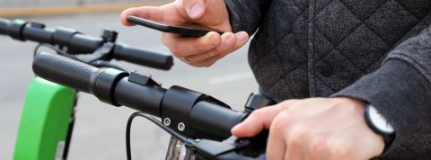 Pourquoi détestons-nous les trottinettes électriques Un homme paye une trottinette électrique avec son smartphone.