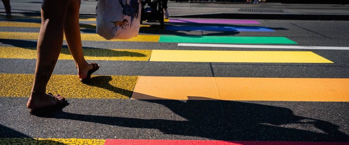 « Soyons Sérieux ! » : le premier dispositif de sensibilisation d'inclusion LGBTQ au travail Une femme passe sur un passage piéton aux couleurs du drapeau de la communauté LGBT+