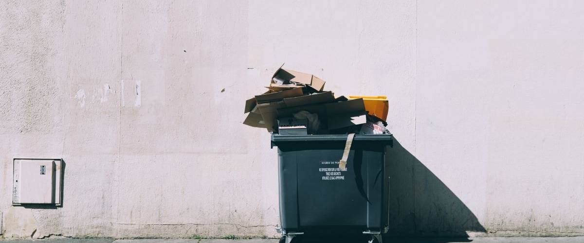 Le gouvernement oblige les fast-food a (vraiment)trier leurs déchets Une benne à ordure noir, contre un mur clair