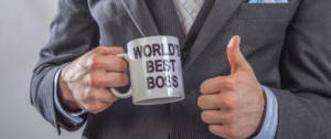 un homme tenant une tasse "world's best boss"