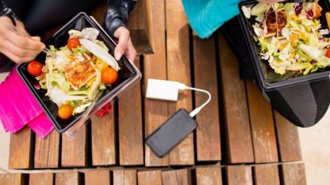 Deux personnes en train de manger des salades en barquette