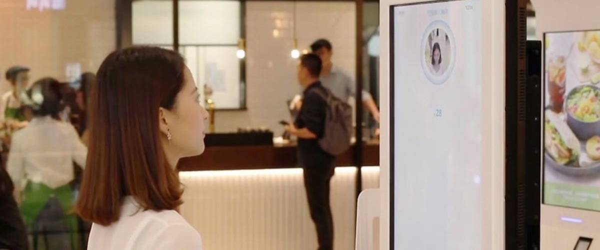 Alipay ajoute des filtres sur ses interfaces de paiement Une femme devant un borne de paiement AliPay
