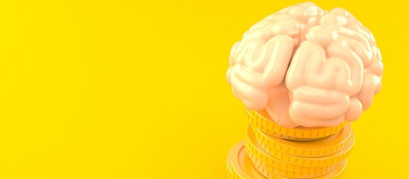 cerveau en or cerveau humain en or massif posé sur une pile de pièces de monnaie