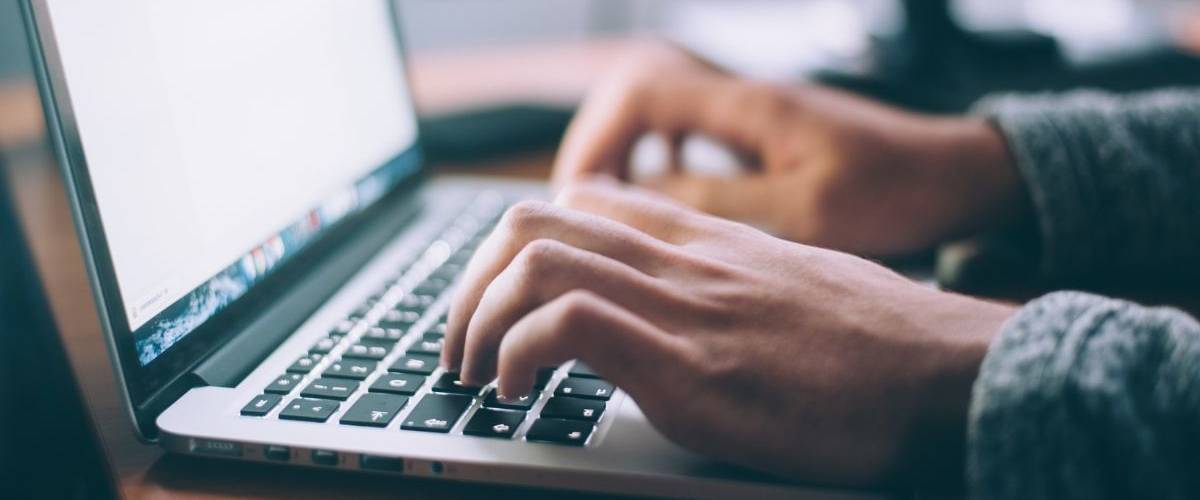L’ADN Groupe recrute un community manager Une homme rédige sur un ordinateur portable