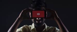 Un homme dissimulé derrière un smartphone sur YouTube