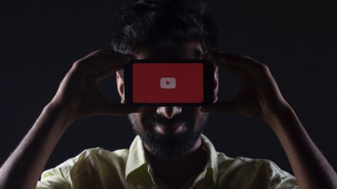 Un homme dissimulé derrière un smartphone sur YouTube