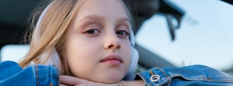 Pour avoir la paix en voiture, les podcast sont fantastiques Une petite fille avec un casque audio sur les oreilles