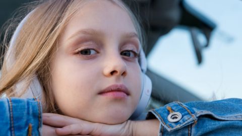 Une petite fille avec un casque audio sur les oreilles