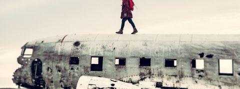 On a rencontré ceux qui ne veulent plus prendre l'avion Un homme qui marche sur une carcasse d'avion