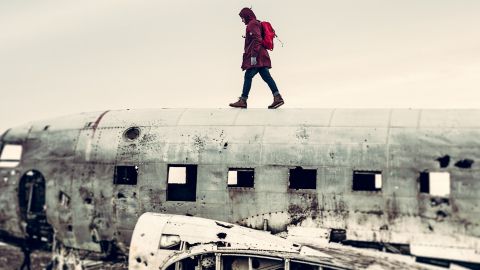 Un homme qui marche sur une carcasse d'avion