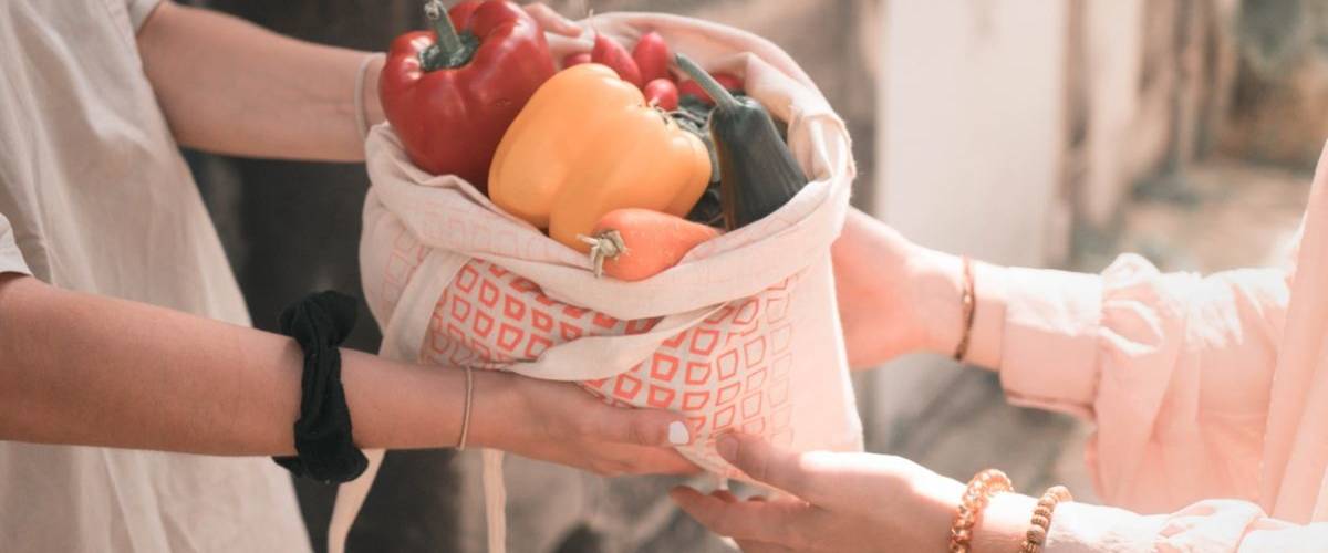 La start-up Geev lance son service de don alimentaire entre particuliers Deux personnes s'échangent un sac de fruits et de légumes