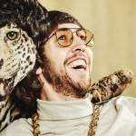 un homme pose avec un léopard empaillé