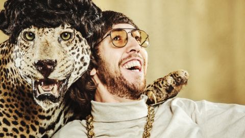 un homme pose avec un léopard empaillé