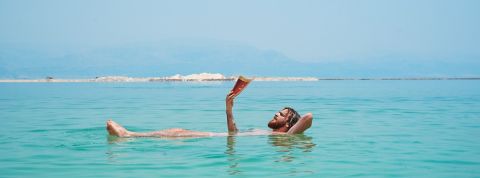 Êtes-vous beach brain ready ? 3 BD sur la tech pour revenir de vacances plus cultivé Homme à barbe lit dans l'eau.