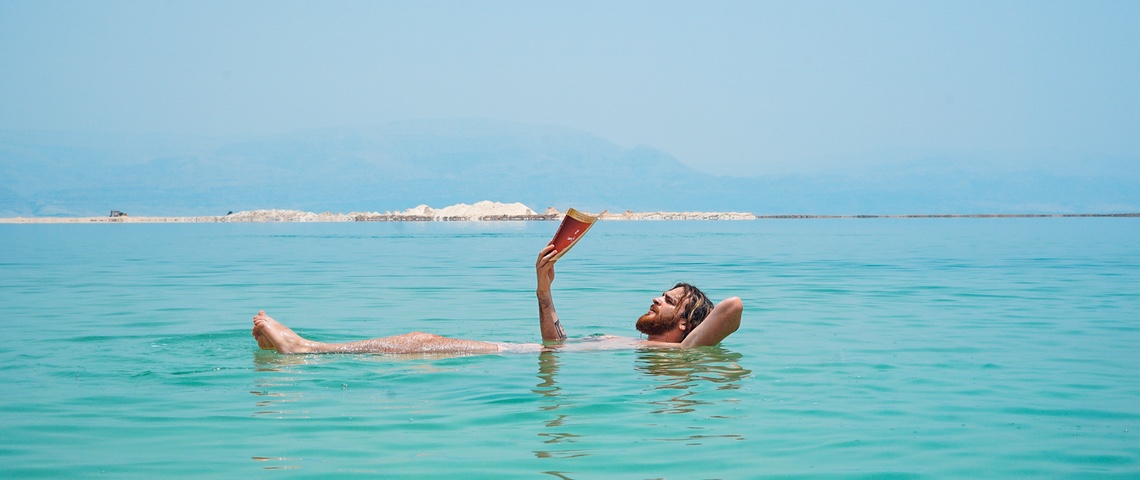 Êtes-vous beach brain ready ? 3 BD sur la tech pour revenir de vacances plus cultivé Homme à barbe lit dans l'eau.