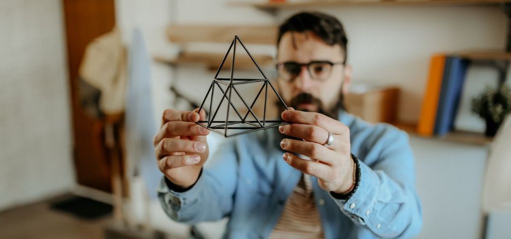 Pouvons-nous tous être designers ? Un homme designer tient un prisme dans sa main
