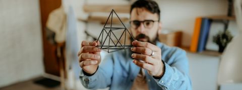 Pouvons-nous tous être designers ? Un homme designer tient un prisme dans sa main