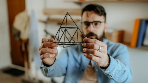 Pouvons-nous tous être designers ? Un homme designer tient un prisme dans sa main
