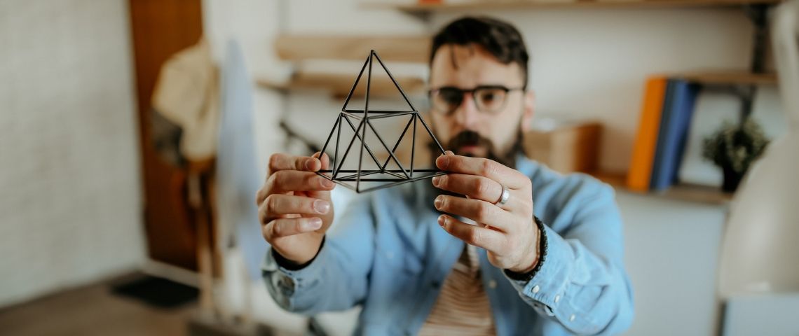 Pouvons-nous tous être designers ? Un homme designer tient un prisme dans sa main