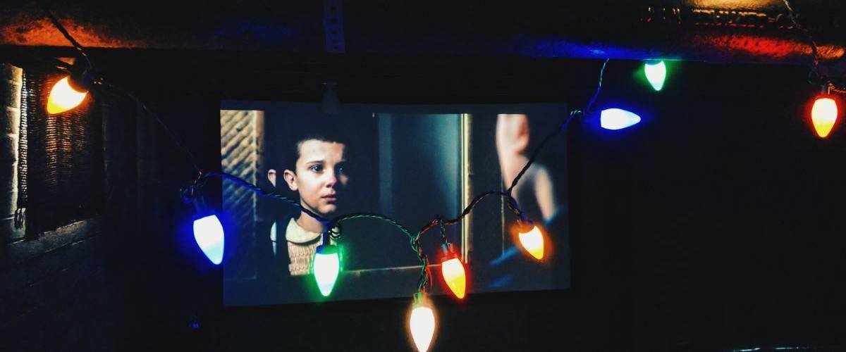 Netflix va réduire son budget de production contenus originaux Télévision dans un salon, diffusant la série Netflix, Stranger Things
